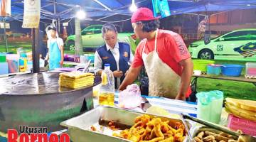 KEBERSIHAN: Pegawai Kesihatan memeriksaan tahap kebersihan pengendali makanan.