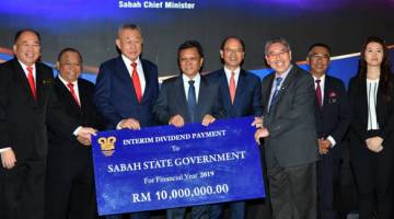 DIVIDEN: Shafie (empat kiri) menerima penyampaian replika cek pembayaran dividen interim SCC berjumlah RM10 juta kepada kerajaan negeri.