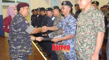 PENGHARGAAN: Hazani menyampaikan sijil penghargaan kepada salah seorang anggota pasukan keselamatan pada majlis itu.