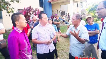 TINJAU: Peter (kiri) ketika meninjau kawasan perumahan Taman Sri Rugading semalam.