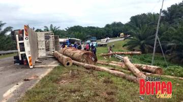 TERBALIK : Lori balak hilang kawalan dan terbalik di Jalan Kalabakan-Sapulut.