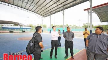 PERIKSA GELANGGANG: Phoong memeriksa gelanggang bola keranjang yang telah diubahsuai di Kompleks Sukan Likas Kota Kinabalu.