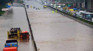 TERPERANGKAP: Kenderaan dilihat terperangkap di jalan tol yang dinaiki banjir di Bekasi, Jawa Barat semalam selepas hujan lebat melanda beberapa kawasan kejiranan di Jakarta, Indonesia. — Gambar AFP