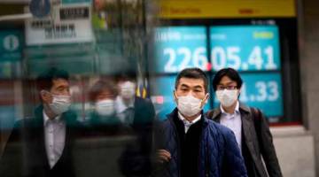 BERHATI-HATI: Orang ramai memakai topeng muka dilihat berjalan di jalan raya di  Tokyo,                                                                  Jepun ekoran kebimbangan mengenai COVID-19 selepas seorang mangsa keempat dari kapal persiaran Diamond Princess yang diuji positif bagi virus itu dilaporkan meninggal dunia. — Gambar AFP
