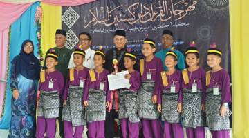 BERSAMA PEMENANG: Arifin (tengah) bersama kumpulan Ar Rayyan dari SK Bandau yang menjadi johan dalam bahagian nasyid Mahrajan al-Quran dan Kesenian Islam itu.