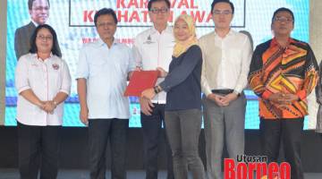 SUMBANGAN: Shafie menyerahkan apresiasi Jabatan Kesihatan Negeri Sabah kepada salah satu wakil rakan penganjur Majlis Perasmian Karnival Kesihatan Awam di Perkarangan Kompleks Sukan Likas, Kota Kinabalu.