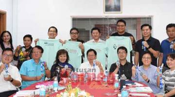 SERTAI LARIAN: Lau (duduk, tengah), Ivy (duduk, dua kanan) dan yang lain menunjukkan medal dan baju-T larian ‘Kidney Run 2020’ pada sidang media di Sibu semalam.