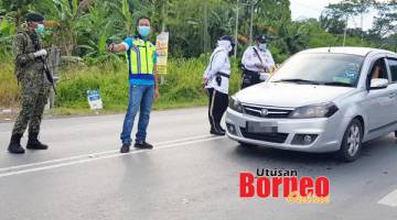 TERATUR: Nasri bersama pasukan yang membuat sekatan jalan raya.