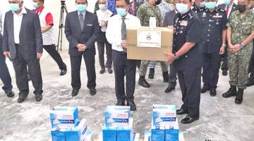 TERIMA: Pesuruhjaya Polis Sabah Datuk Zaini Jass menerima bekalan topeng muka dan cecair pembasmi kuman daripada Shafie.