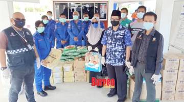 BANTUAN : Khalid (dua kanan) dan Kahar (kanan) menyampaikan sumbangan kepada petugas barisan hadapan di IPG Kampus Tawau.