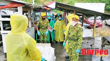 BERGERAK: Anggota RELA turut membantu mengagihkan bantuan bekalan harian kepada penduduk di Kampung Sim-Sim.