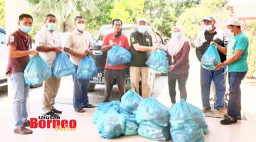 BANTUAN: Hajiji (lima kiri) menyerahkan bantuan makanan kepada ketua dan wakil empat buah kampung dalam kawasan DUN Sulaman.