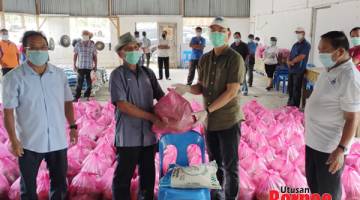 BANTUAN: Madius menyampaikan sumbangan kepada salah seorang MPKK sambil disaksikan Joisin (kiri) dan Suali (kanan).