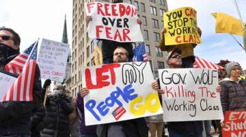 DEGIL: Orang ramai yang marah menunjuk perasaan di jalanan untuk menuntut kerajaan                     menamatkan sekatan pergerakan di Pennsylvania, kelmarin. — Gambar AFP