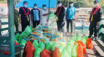 SUMBANGAN: Ketua Kampung Pulau Sepanggar mewakili penduduk menerima sumbangan berupa barangan keperluan daripada YADIM.