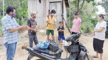 KEBERSIHAN: Seorang kakitangan sekolah menunjukkan cara membersihkan tangan kepada seorang pelajar sambil diperhatikan oleh Mohd Zuki (kiri) dan Penolong Kanan 1 SK Golong, Norzin Sairon (dua kiri). 