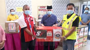 SUMBANGAN: Yusof memerhatikan Pengurus ADABI Sabah Distribution Sdn Bhd Muhamad Zahari Muhd Nasir menyampaikan juadah berbuka kepada Timbalan Ketua Polis Daerah Kota Kinabalu Superintendan George Abdul Rakman.