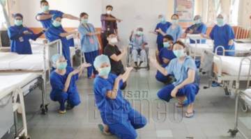 DISCAJ: Pasukan petugas barisan hadapan meraikan pesakit yang dirawat di Unit Rawatan Rapi Hospital Tawau apabila disahkan sembuh dan discaj dari hospital.