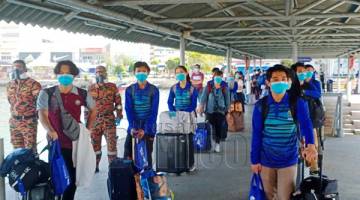 SARINGAN: Pelajar menunggu giliran untuk pemeriksaan saringan suhu badan sebelum dibenarkan naik ke kapal ekspres yang membawa mereka pulang ke Limbang, Sarawak di Terminal Feri Penumpang Antarabangsa Labuan, Sabtu lalu.