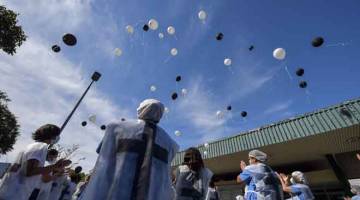 PENGHORMATAN: Kakitangan perubatan melepaskan belon ketika memberi penghormatan            kepada rakan sekerja yang meninggal dunia akibat COVID-19 di luar Hospital Universiti Sao Paulo di Sao Paulo, Brazil pada 12 Mei lalu. — Gambar AFP