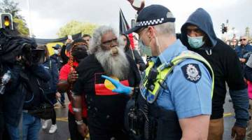 PERBALAHAN: Aktivis Orang Asal Australia Herbert Bropho (tengah) bertengkar dengan seorang pegawai polis semasa menyertai protes Black Lives Matter tanda solidariti dengan penunjuk perasaan di Amerika Syarikat. Orang Asal Australia mengadakan protes tersebut bagi menuntut agar pihak berkuasa menghentikan kematian suspek daripada kaum mereka dalam tahanan reman di Perth, kelmarin. Ribuan penunjuk perasaan berhimpun di seluruh bandar utama di negara itu kelmarin bagi menuntut kesaksamaan hak kaum di sebalik a