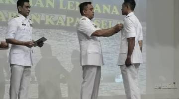 LENCANA: Mohd Reza semasa memakaikan Lencana Kepakaran Kapal Selam kepada salah seorang pelatih yang berjaya menamatkan latihan.
