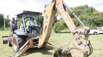 PECAH TANAH: Adham (duduk) melakukan simbolik pecah tanah Projek Kuarters Kakitangan Jabatan Kesihatan Labuan.