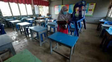  Guru kelas Tahun 6 Intan, Fatimah Azzahrah Amat Ramsa membersihkan semua kerusi dan meja para pelajar ketika tinjauan di Sekolah Kebangsaan Datuk Wan Kemara, Changlun di Kedah. - Gambar Bernama 