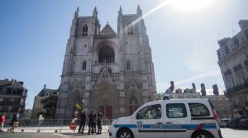 DIKAWAL RAPI: Anggota bomba berdiri di hadapan katedral Saint-Pierre-et-Saint-Paul di Nantes, barat Perancis, 20 Julai lalu, dua hari selepasa kebakaran di tiga bahagian berasingan. ­— Gambar AFP