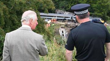 TURUN PADANG: Putera Britain, Putera Charles melawat tempat insiden nahas kereta api di Stonehaven, timur laut Scotland. — Gambar AFP