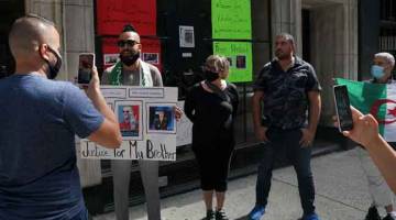 BEBAS SEGERA: Chekib bercakap menerusi media sosial ketika disertai beberapa rakannya menuntut pembebasan Drareni di luar konsulat Algeria di New York, kelmarin. — Gambar AFP