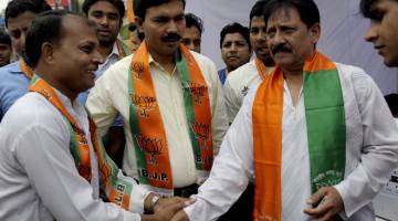 TIDAK TERKECUALI: Gambar fail 6 April, 2009 menunjukkan pemain kriket kebangsaan dan calon Parti Bharatiya Janta (BJP) dari timur Delhi Chetan Chauhan (kanan) berjabat tangan dengan para pekerja parti ketika berkempen bagi pilihan raya umum di New Delhi. Bekas pemain pembukaan Test India itu yang membentuk kerjasama prolifik dengan Sunil Gavaskar, meninggal dunia pada usia 73 tahun akibat jangkitan COVID-19, menurut adik lelakinya kelmarin. — Gambar AFP