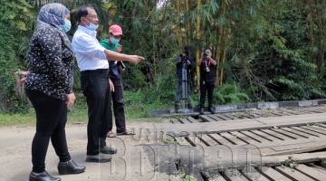 TINJAU : Jaujan turun padang meninjau keadaan jambatan alternatif jalan Mariano, di sini semalam.