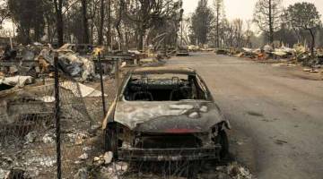 MUSNAH: Bangkai kereta tersadai ditepi jalan selepas dijilat api dalam kebakaran hutan di Phoenix, Oregon. — Gambar AFP