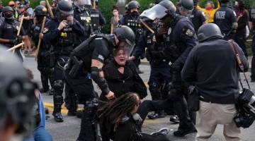 HURU-HARA: Anggota polis menangkap penunjuk perasaan yang membantah keputusan                   pihak berkuasa berhubung kes Breonna Taylor di Louisville, Kentucky kelmarin. — Gambar AFP
