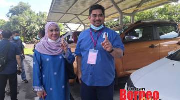 SELESAI UNDI: Ir Shahelmey dan isteri Dayang Siti Nur Hayyat Ag Mohd Saufi menunjukkan jari telunjuk kiri yang berwarna biru tanda telah selesai melaksanakan tanggungjawab sebagai seorang pengundi.