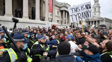 MELAMPAU: Anggota polis antirusuhan bergerak untuk meleraikan protes di Trafalgar Square, London kelmarin yang dibanjiri rali umum ‘Kami Tidak Benarkan!’ — Gambar AFP