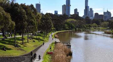 LEGA: Orang ramai bersiar-siar dan bersenam di sepanjang tebing Sungai Yarra di Melbourne, kelmarin ketika perintah berkurung waktu malam di bandar kedua terbesar di Australia itu ditarik balik mulai semalam. — Gambar AFP