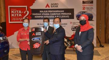 TAHNIAH: Ahmad  Hamzah (tengah) menyampaikan hadiah berupa replika kunci Ford Ranger pada pemenang Cheng Siew Chan (kiri) sambil diperhatikan oleh Datuk Che Abdullah Mat Nawi (dua kiri) dan Khadijah Iskandar.