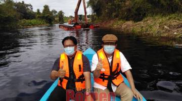 PANTAU: Juanda (kanan) dan Wan Hipni ketika meninjau kerja-kerja pembersihan sungai di Matu, baru-baru ini.