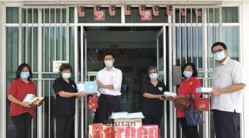 SUMBANGAN: Chin (tiga kiri) menyampaikan kuih bulan kepada kakitangan PIBAKIS sambil disaksikan Lee (kiri) dan Teo (kanan).