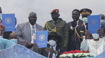 MERDEKA: Al-Burhan (kiri), Salva Kiir (tengah) dan Presiden Chad Idriss Deby (kanan) memegang salinan perjanjian damai Sudan Selatan yang ditandatangani di Juba, kelmarin. — Gambar AFP
