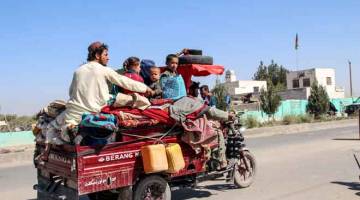LARI: Penduduk bersama harta benda yang dapat dibawa bersama melarikan diri dari daerah Nadali ke Lashkar Gah di Helmand, kelmarin. — Gambar AFP