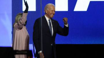 YAKIN MENANG: Biden dan isterinya Dr. Jill Biden mengangkat tangan selepas beliau berucap pada malam pilihan raya di Chase Center, Wilmington, Delaware kelmarin. Trump pada awal semalam mendakwa memenangi pilihan raya AS 2020 dan akan membuat kenyataan dalam waktu terdekat, lapor Sputnik. — Gambar AFP