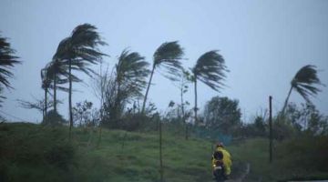 RIBUT KENCANG: Penunggang motosikal melalui jalan di tengah-tengah ribut kencang                                        di Legazpi, wilayah Albay, Filipina semalam menjelang ketibaan Ribut Tropika Vamco yang dijangka menjadi bertambah kuat kepada taufan di rantau yang telah pun terjejas oleh dua taufan dalam kurang dari tiga minggu. — Gambar AFP