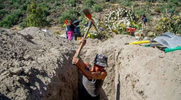 KUBUR: Pekerja menggali lubang di tanah perkuburan di Bandar Pantheon, Valle de Chalco kelmarin ketika Mexico dilaporkan mencatatkan lebih 100,000 kematian akibat COVID-19. — Gambar AFP 