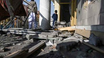 ROSAK: Orang awam memeriksa kerosakan yang disebabkan oleh serangan roket di Khair Khana di Kabul, Afghanistan. — Gambar AFP