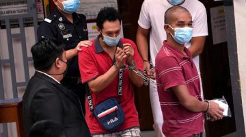 DIDAKWA: Mohd Zamidi diiringi anggota polis sebaik tiba di Mahkamah Majistret Kangar atas pertuduhan mengedar dadah jenis syabu dan ganja seberat 226 kilogram pada September lalu. — Gambar Bernama