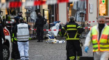 SIASAT: Anggota polis dan ambulans dilihat sedang menjalankan tugas di lokasi di mana sebuah kenderaan SUV merempuh              pejalan kaki di Trier, barat daya Jerman kelmarin. — Gambar AFP