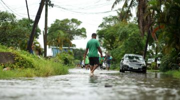 BANJIR: Penduduk mengharungi jalan raya yang dilanda banjir di Suva kelmarin menjelang ketibaan Taufan Yasa. — Gambar AFP